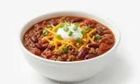 Berts-Classic-Beef-Chili-Bowl A bowl of hearty beef chili topped with melted cheese and sour cream.