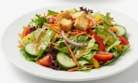 Fresh-Garden-Salad-White-Plate Fresh garden salad with mixed greens, tomatoes, cucumbers, and crunchy croutons.