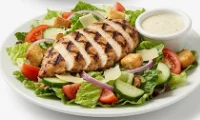 Grilled-Chicken-Salad-Healthy-Dinner Grilled chicken breast slices on a fresh garden salad with creamy dressing.